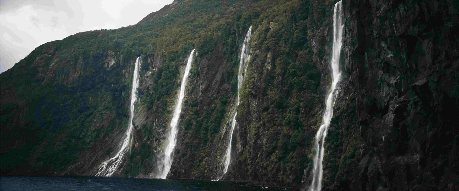 Four Sisters waterfalls cascading into the fiord