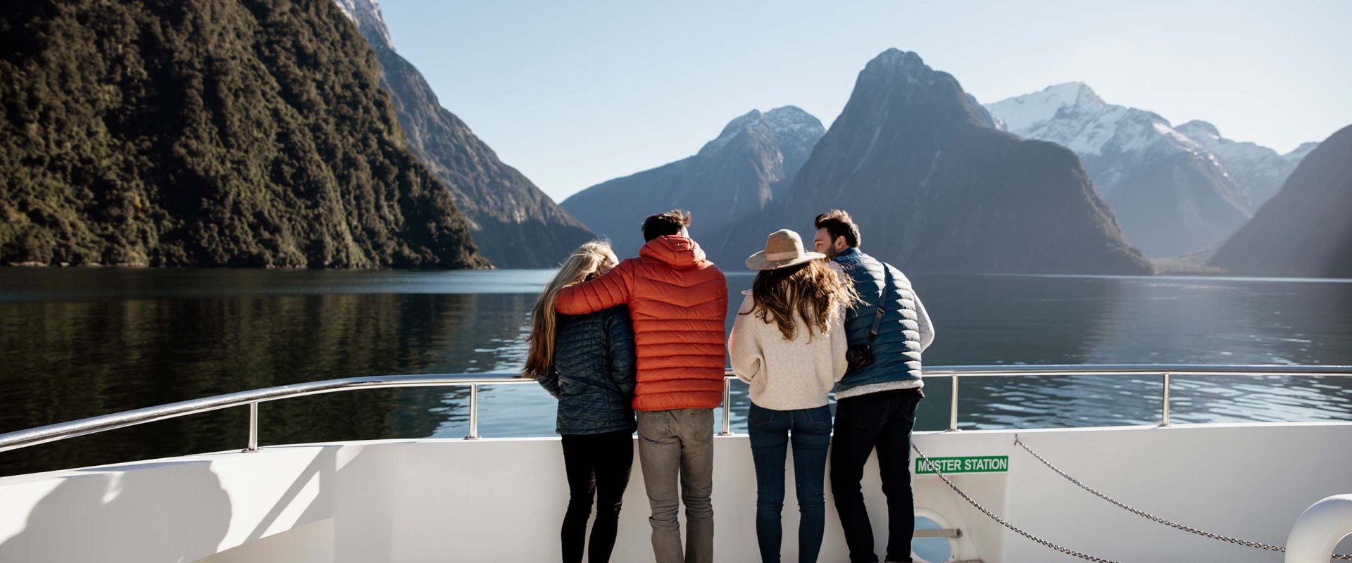 A group of friends enjoys stunnings views of Mitre Peak in the sunshine