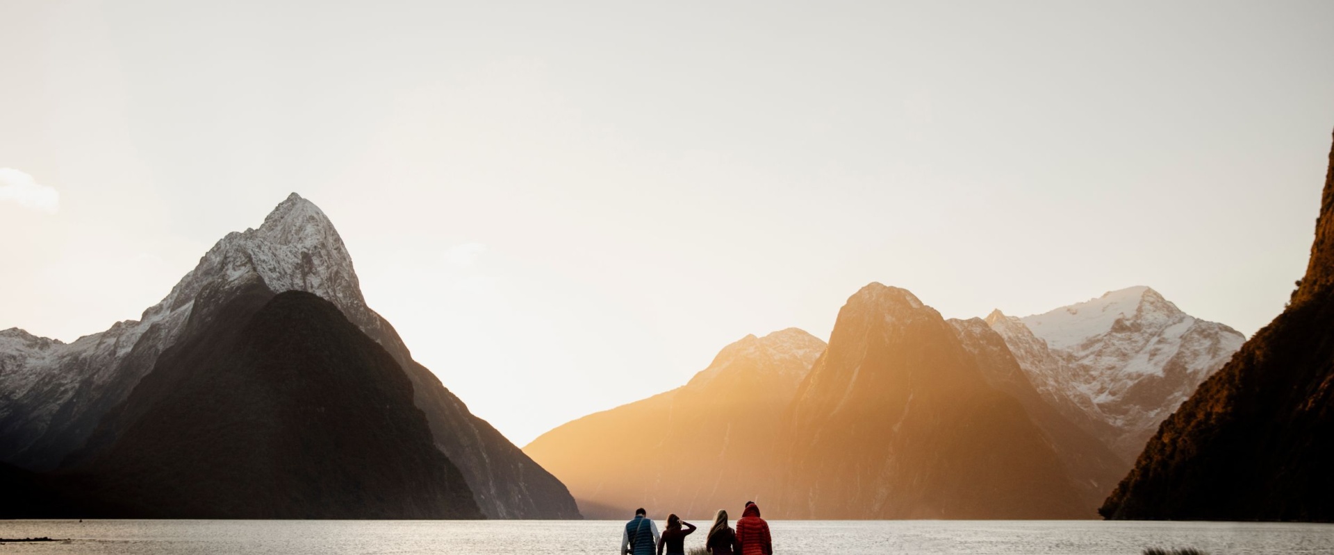 Sunset on the foreshore as a group of 4 friends look out over Mitre Peak and the fiord
