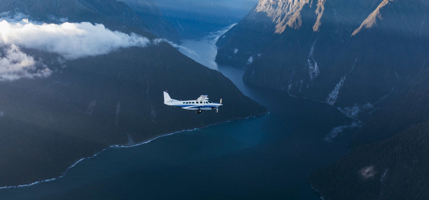 A True South flights plane soars over the fiords, showcasing the stunning Fiordland scenery 